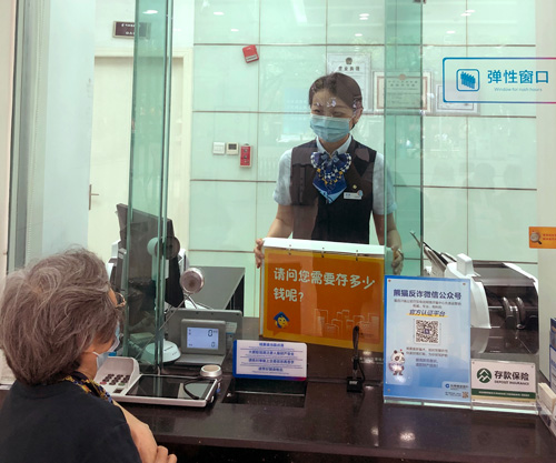 建行成都金河支行，柜面員工使用“關愛服務卡”服務老年客戶